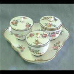 Sevres condiment set with lids. Floral decorations throughout. Jars  set on a triangular shaped scal