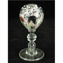 A glass paperweight on baluster stemmed st...