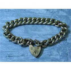 A 9ct gold curb bracelet with a heart lock...