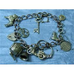 A 9ct gold charm bracelet with fourteen ch...