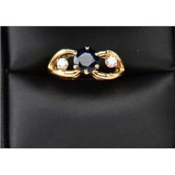 One ladies ring in 14k yellow gold set with a  round blue sapphire weighing 1.41ct and 2  side diamo