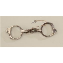 Antique H&R Arms Co. pair of handcuffs with  key showing approx. 60% original nickel  finish with ba