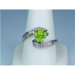 Pleasant 14 karat white gold ladies by-pass  design ring set with a trilliant cut peridot  weighing 