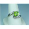 Image 2 : Pleasant 14 karat white gold ladies by-pass  design ring set with a trilliant cut peridot  weighing 