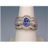 Image 1 : Sensational 14 karat two-tone gold ladies  ring set with a center oval Tanzanite  weighing approx. 1