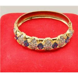 One 14k yellow gold hinged bangle bracelet  set with 5 oval cut sapphire weighing approx.  10ct and 