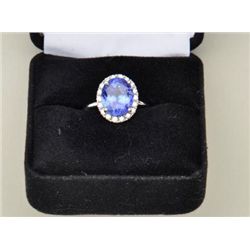 One ladies ring in 14k white gold set with a  3.38ct oval tanzanite and a halo of diamonds.  Est. $2