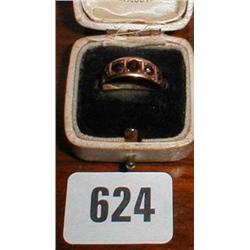 A gold garnet set band marked 375...