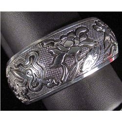2304 - TIBETAN SILVER CUFF BRACELET W/LOTUS AND OTHER OBJECTS