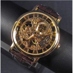 5740 - MENS GOLD TONE SKELETON WATCH W/ QUARTZ MOVEMENT AND LEATHER BAND
