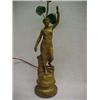 Image 1 : Gilt metal figural lamp of woman holding torch, one foot on books