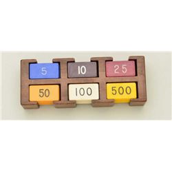 Lot of rectangular gambling chips in wood  rack in denominations of 5, 10, 25, 50, 100  and 500 in c