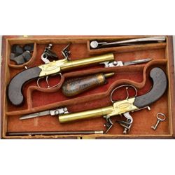Cased pair of center hammer Flintlock pistols  with spring bayonets and constructed of  brass in ori