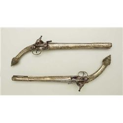 Pair of Balkan Flintlock pistols with cast  ornate silvered stocks and miquelet locks,  circa late 1