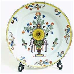 AN 18TH CENTURY POLYCHROME DELFT CHARGER centred a floral display and with floral sprigs to border,.