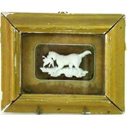 A FINELY CARVED IVORY SPORTING DOG retreiving a duck, mounted an incised wood panel of trees, 2" x 3