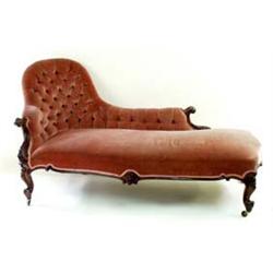 A VICTORIAN ROSEWOOD CHAISE LONGUE the buttoned back with carved scroll ends, foliate carved to knee