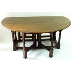 AN 18TH CENTURY STYLE ELM DINING TABLE with "D" shaped drop leaves, of good honey colour, on turned.