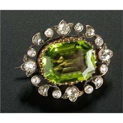 A late Victorian peridot and diamond brooch, centred with a canted-rectangular trap-cut peridot with