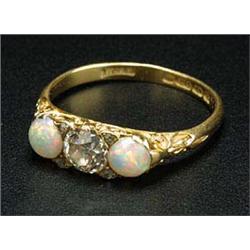 An Edwardian 18ct gold, opal and diamond three stone carved half-hoop ring, centred with an old-cut.