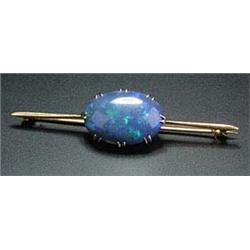 A black opal single stone bar brooch, the oval cabochon claw set to a tapered bar(see illustration).