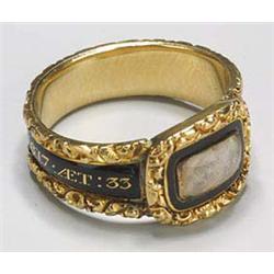 A late George III gold and black enamel mourning ring, the front with an oblong hair-glazed panel, t