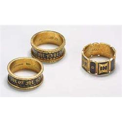 Three 18ct gold and black enamel mourning band rings, comprising; a pair with raised floral chased b