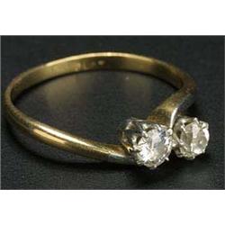 A diamond two stone cross-over ring, the old-cut stones approx. 0.25 and 0.23cts, claw set in white.