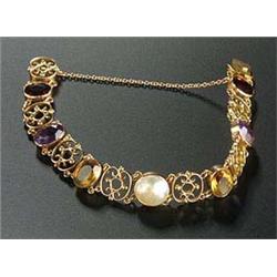 An early 20th century rose gold and multi-gem bracelet, centred with a round blister pearl, two oval