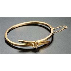An Edwardian gold, half-pearl and diamond hollow hinged bangle of square section cross-over design,.