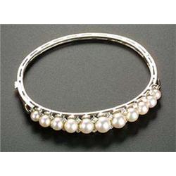 A modern cultured pearl and diamond half-hoop bangle, the front set with eleven graduated cultured p