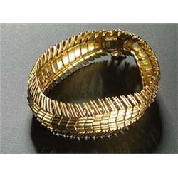 An 18ct gold bracelet, of broad chevron-shaped stiff links, London 1959, 70.8g, in a Garrard & Co Lt