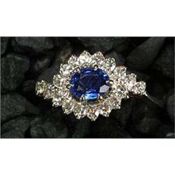 A sapphire and diamond cluster ring of cross-over design, centred with an oval mixed-cut sapphire wi