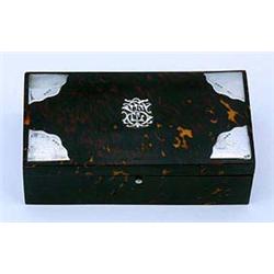 A late Victorian tortoiseshell and silver mounted cigarette box, the hinged cover with a central mon