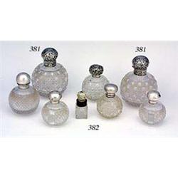 A cut-glass and silver mounted spherical scent bottle, the hinged cover embossed with flowers leaves