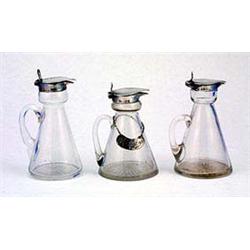 Three glass and silver mounted whiskey noggins, of conical form the mounts Birmingham 1910, 1915 & 1