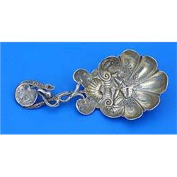 A Victorian caddy spoon, the lobed bowl embossed with shells and leaves the handle in the form of a.