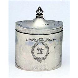 An oval tea caddy engraved with a ribbon bow and floral cartouche with crest, the hinged cover with.
