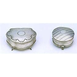 A silver cartouche shaped jewellery box, on four feet, the hinged cover stamped to resemble hammered