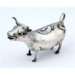 A cow creamer, the head with ruby-glass eyes, the hinged cover with engraved flowers and a fly finia
