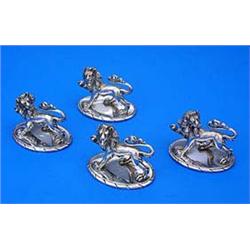 A set of four Victorian pepper pots, each cast and chased in the form of a Lion passant on an oval b