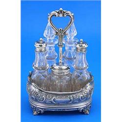 A Victorian oblong five bottle cruet stand, embossed with flowers, scrolls, diaper and cartouches wi