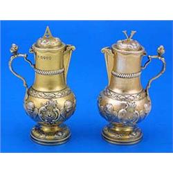 A pair of silver gilt baluster shaped Water & Wine cruets, embossed with winged putti and leaf scrol