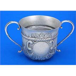 A Queen Anne porringer with two beaded S scroll handles, embossed with spiral flutes, a rope band an