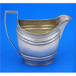 A George III oval milk jug, with reeded borders and handle and bright cut engraved with a band of le