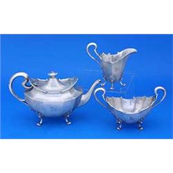 An oblong facetted three piece tea service, each with a crest, a moulded shaped scroll border and fo