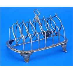 A George III six division toast rack with a nulled border on scroll feet, London 1809 by Rebecca Eme