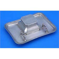 An ink stand of concave oblong outline, engine turned with a reeded border and a central ink well an