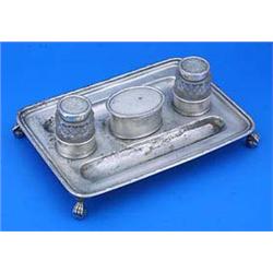 An oblong inkstand with reed and ribbon border, a central oval sand box, and two pen recesses, on ba