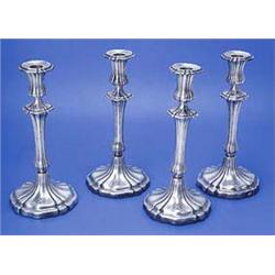 A set of four William IV candlesticks with lobed columns and petal shaped bases engraved with a shie